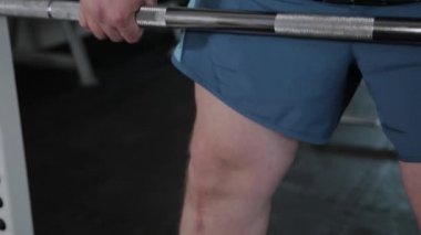 Kilolu yetişkin adam spor salonunda deadlift gerçekleştirir.