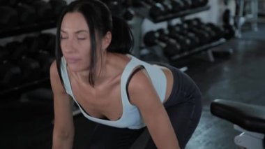 Güzel atletik kadın spor salonunda deadlift gerçekleştirir.