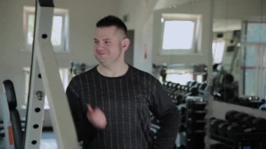 Yetişkin adam sevinir ve spor salonunda müzik bir hızda hareket eder.