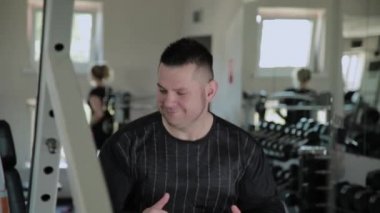 Yetişkin adam sevinir ve spor salonunda müzik bir hızda hareket eder.