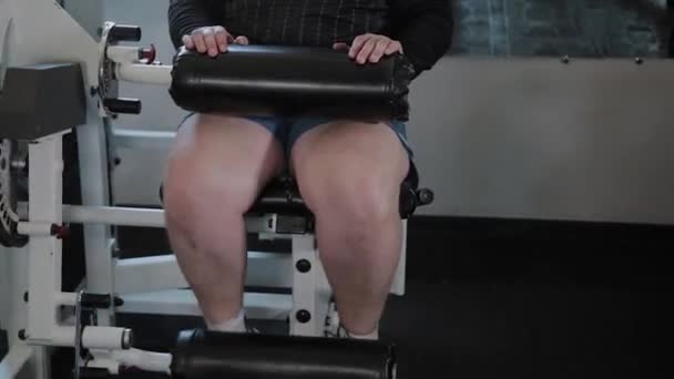 Vuxen man med övervikt utför ben förlängning. — Stockvideo