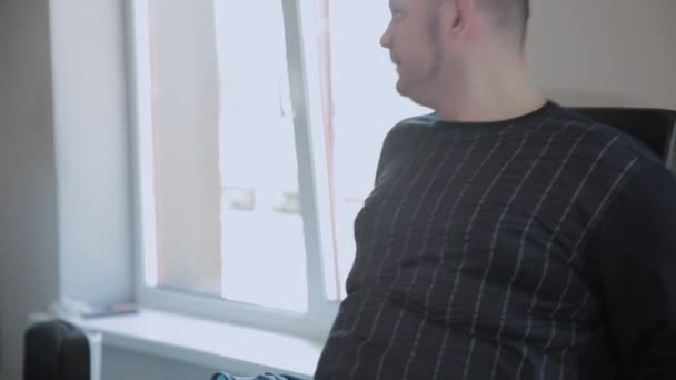 Erwachsener Mann mit Übergewicht drückt seine Beine auf den Simulator. — Stockvideo