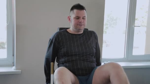 Ενήλικος άντρας με υπέρβαρο πιέζει τα πόδια του στον προσομοιωτή. — Αρχείο Βίντεο