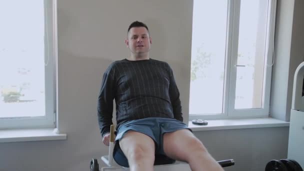 Felnőtt ember túlsúlyos prések lábait a szimulátor. — Stock videók