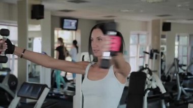 Güzel atletik kadın ayakta bir halter yapıyor.