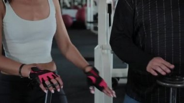 Yetişkin kilolu adam ve güzel kadın spor salonunda barbells ile dans.