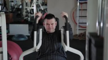 Aşırı kilolu yetişkin adam simülatör göğsünü trenler.