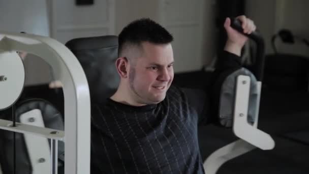 Homem adulto com excesso de peso treina seu peito no simulador . — Vídeo de Stock