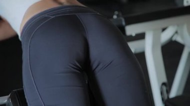 Genç güzel kadın spor salonunda hiperuzantısı gerçekleştirir.