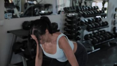 Güzel atletik kadın spor salonunda deadlift gerçekleştirir.