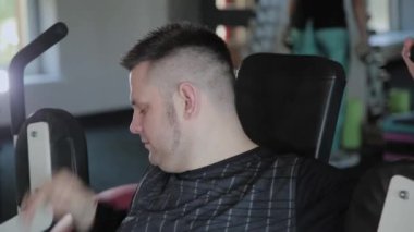 Aşırı kilolu yetişkin adam simülatör göğsünü trenler.