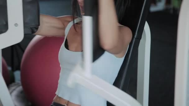 아름다운 운동 여자는 시뮬레이터에 가슴 근육을 훈련. — 비디오