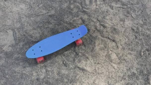 Skateboard debout sur le sable par beau temps . — Video
