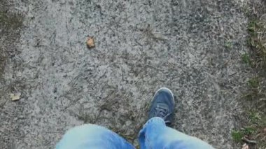 Pantolonlu yürüyen bir adamın bacakları. Üstte görüntü.