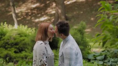 Güzel mutlu genç çift güneşli havalarda sokakta parkta kucaklayan.