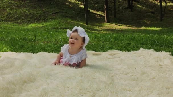 Velmi malá a krásná dívka, která si hrála na posteli v parku. — Stock video