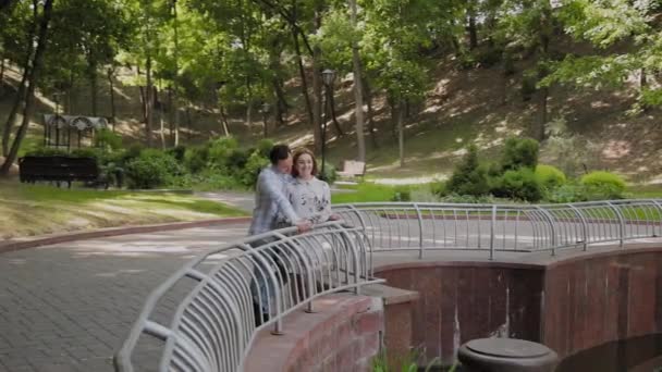 Ευτυχισμένοι εραστές αγκαλιάζονται από το φράχτη συντριβάνι. — Αρχείο Βίντεο