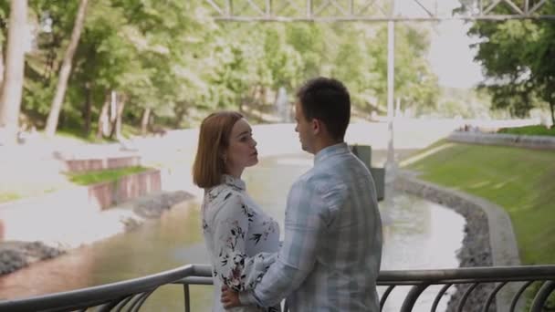 Gelukkige liefhebbers knuffelen bij de fontein hek. — Stockvideo