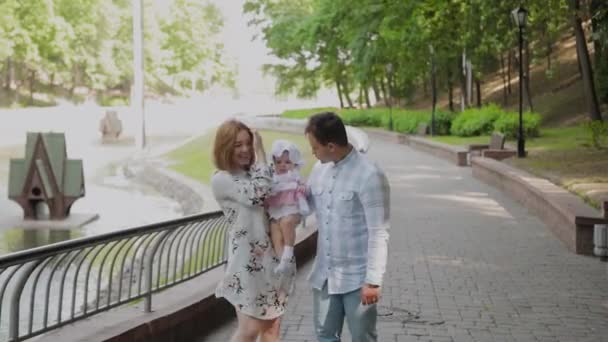 Счастливая семья с маленьким ребенком гуляет в парке . — стоковое видео