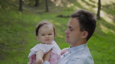 Genç baba bebeği kollarında tutuyor..