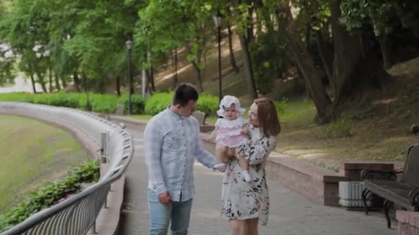 Família feliz com uma criança pequena andando no parque . — Vídeo de Stock