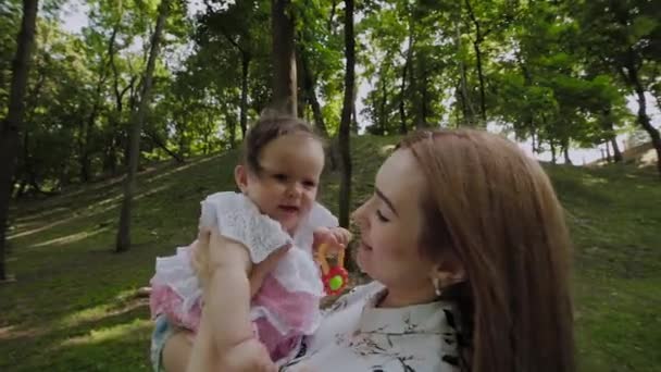 Bela jovem mãe segura o bebê em seus braços . — Vídeo de Stock
