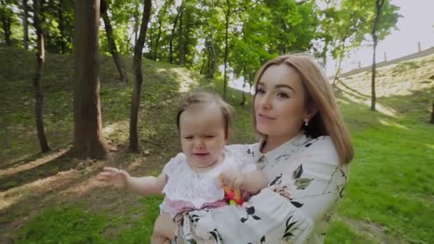 Красива молода мати тримає дитину на руках . — стокове відео
