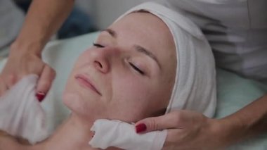 Bir kadın güzellik salonunda özel mendiller ile temizlenir.