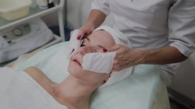 Bir kadın güzellik salonunda özel mendiller ile temizlenir.