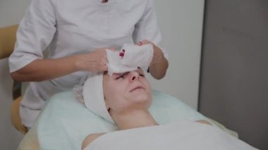 Bir kadın güzellik salonunda özel mendiller ile temizlenir.