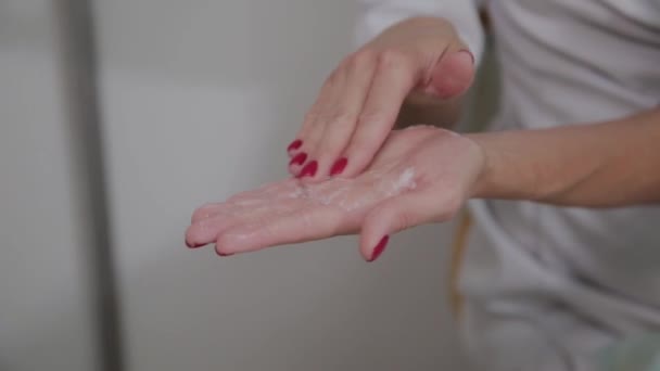 Cosmetologist profissional esfrega o creme de massagem . — Vídeo de Stock