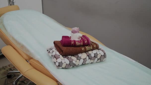 Salons pour massage thaï avec serviettes, oreillers et fleurs en chambre vide . — Video