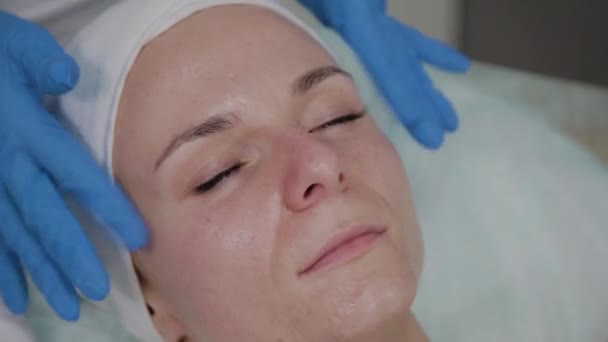 Cosmetologo professionista che fa massaggi facciali nel salone di bellezza . — Video Stock