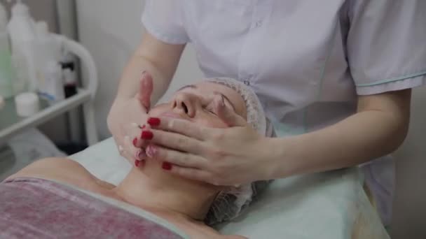 Профессиональный косметолог массирует крем . — стоковое видео