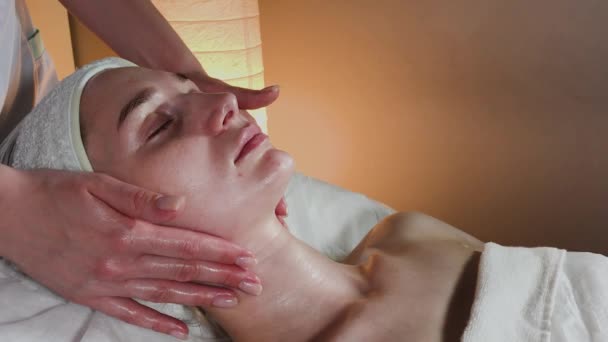 Professionele schoonheidsspecialiste maakt een complexe massage aan een jong meisje in het cosmetologie kantoor. — Stockvideo