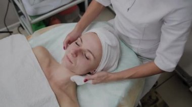 Bir kadın güzellik salonunda özel mendiller ile temizlenir.