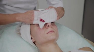 Bir kadın güzellik salonunda özel mendiller ile temizlenir.