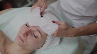 Bir kadın güzellik salonunda özel mendiller ile temizlenir.