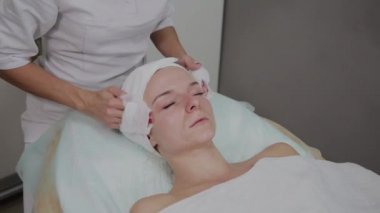 Bir kadın güzellik salonunda özel mendiller ile temizlenir.