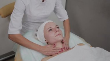 Profesyonel kozmetolojist kız yüzüne nemlendirici uygular.