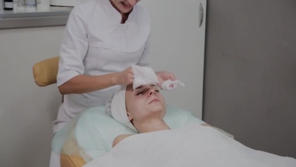 Una mujer se limpia con toallitas especiales en el salón de belleza . — Vídeo de stock