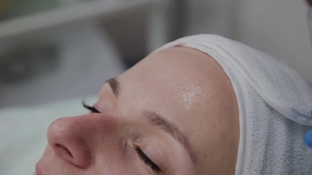 Professionele cosmetoloog past het serum toe op de patiënten die. — Stockvideo