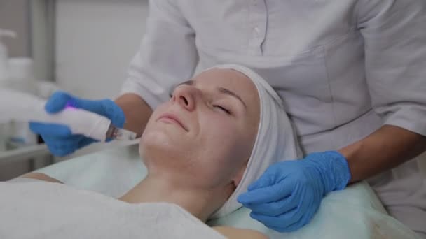 Professionele cosmetoloog voert Dermapen procedure in een cosmetologie kliniek. — Stockvideo