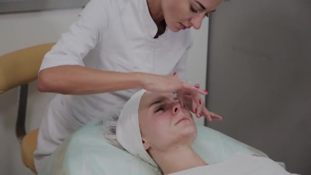 Profesionální kosmetolog používá zvlhčovadlo pro dívčí obličej. — Stock video