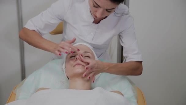 Cosmetologo professionista applica idratante per viso ragazza . — Video Stock