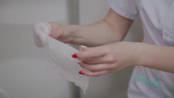 美容師は美容クリニックで洗濯するために手のワイプを拭きます. — ストック動画