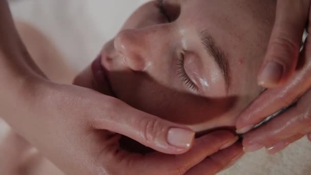 Professionelle Kosmetikerin macht eine komplexe Massage für ein junges Mädchen im Kosmetikbüro. — Stockvideo