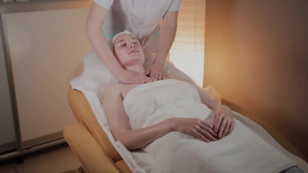 Profesionální beautik dělá složitou masáž mladé dívce v kanceláři kosmetologie. — Stock video