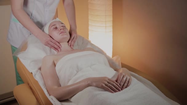 Professionele schoonheidsspecialiste maakt een complexe massage aan een jong meisje in het cosmetologie kantoor. — Stockvideo