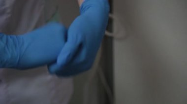 Lastik eldiven hemşire ellerinin üzerinde bir dezenfektan sprey yakın çekim. El dezenfektan çözüm üzerinde oyuncak bir hemşire.